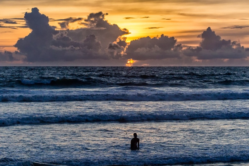 Man going to sea in Bali at sunset
